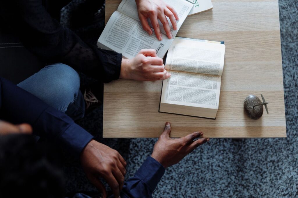 Top view of diverse hands holding open books, creating an engaging reading session.